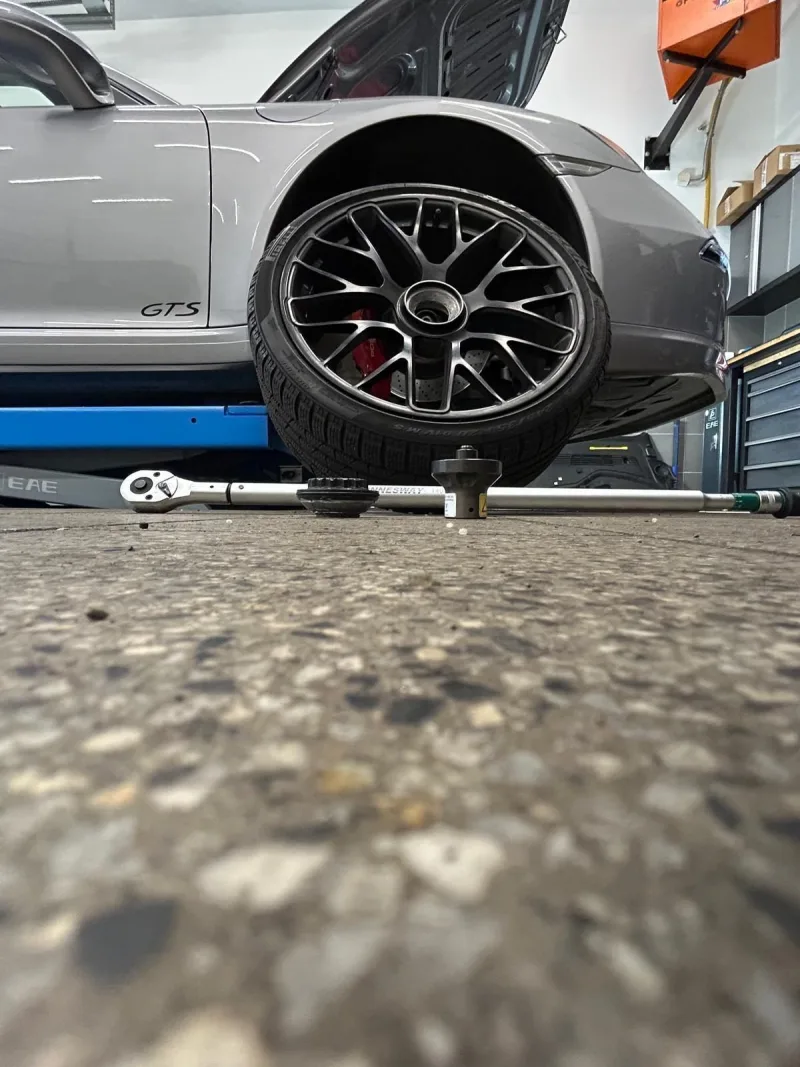 Porsche GTS se sundaným kolem na zvedáku
