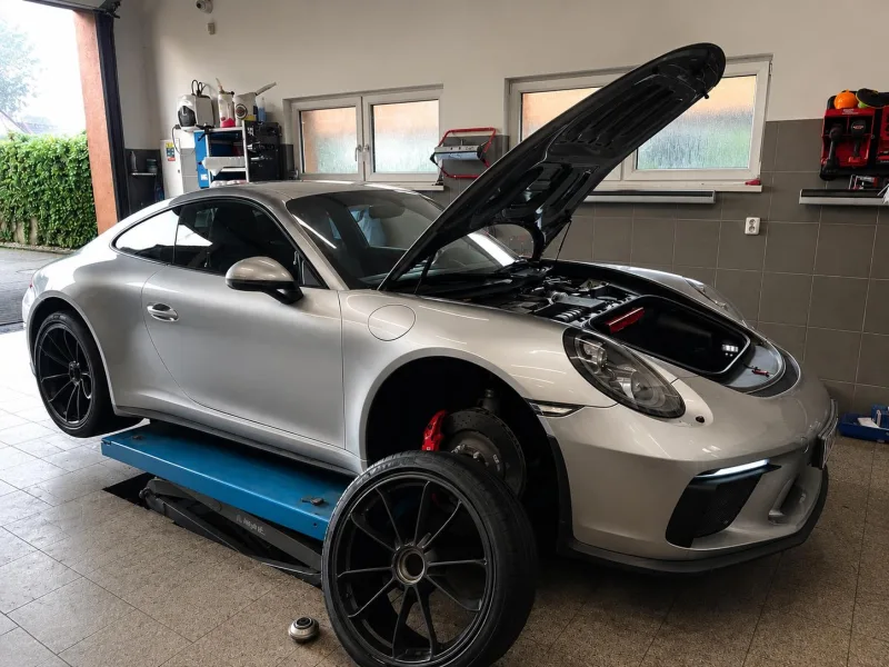 Porsche 911 na zvedáku se sundaným kolem při servisu v autoservisu Brabenec